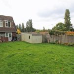 Spacious garden with house and shed.