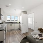 Modern kitchen interior with light wood flooring.