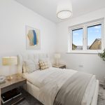 Modern bedroom with double bed and artwork.