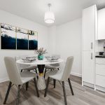 Modern dining area with white decor and artwork.