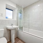 Modern bathroom with bathtub, sink, and toilet.