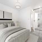Modern bedroom with neutral decor and mirrored wardrobe.