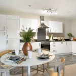 Modern kitchen with dining table and white cabinets.