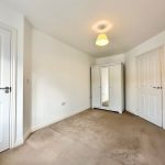 Empty room with wardrobe and white doors.