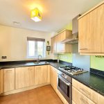 Modern kitchen with wooden cabinets and appliances.