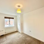 Empty room with window and light fixture.