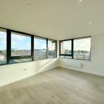Empty room with large windows and city view.