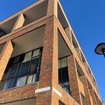 Modern brick building against clear blue sky.