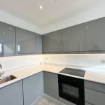 Modern kitchen with grey cabinets and built-in appliances.