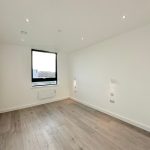 Empty room with window and wooden flooring.
