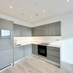 Modern kitchen with glossy grey cabinets.