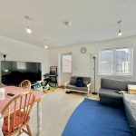 Bright living room with sofa and TV.
