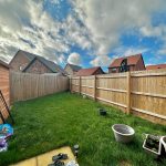 Backyard garden with wooden fence and potted plants.