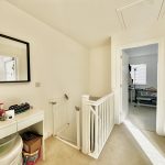 Upstairs hallway with mirror and baby gate.