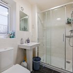 Modern bathroom with shower and frosted window.