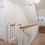 Bright hallway with carpet and white doors.