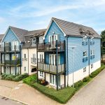 Modern blue residential building with balconies.