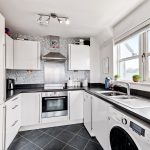 Modern kitchen with white cabinets and appliances.