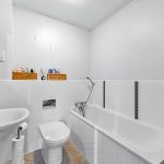 Modern white bathroom with bathtub and sink.