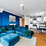 Modern living room with blue sofa and kitchen