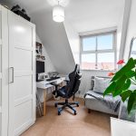 Cosy home office with desk and chair by window.