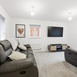 Modern living room with leather sofas and TV.