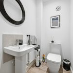 Modern bathroom with sink, mirror, and toilet.