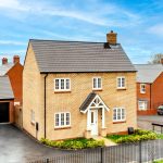 Modern suburban house with driveway and gardens