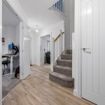 Modern hallway with stairs and office space view.