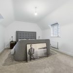 Modern bedroom with grey bed and art piece