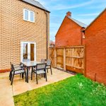 Brick house with garden patio and chairs.