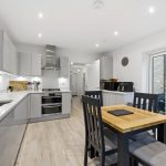 Modern kitchen with dining table and chairs.