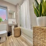 Modern bathroom with plants and woven decor.