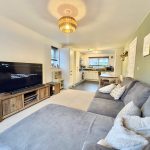 Modern living room with grey sofa and TV.