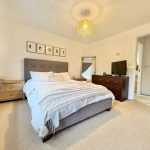 Modern bedroom with grey bed and dresser