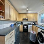 Modern kitchen with wooden cabinets and appliances.