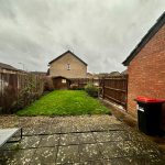 Suburban garden with grass, patio, shed.