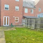 Brick house with fenced garden area.
