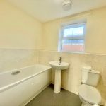 Modern bathroom with bath, sink, and toilet