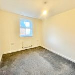 Empty room with grey carpet and window.