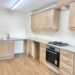 Modern kitchen with wooden cabinets and appliances.