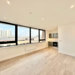 Modern flat interior with city view windows.