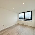 Empty room with large window and wooden floor