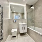 Modern bathroom with shower and vanity.