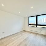 Empty room with wooden floor and city view.