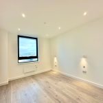 Empty modern room with large window and lighting.