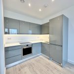 Modern kitchen with grey cabinets and built-in appliances.