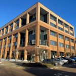 Modern office building with parked cars.