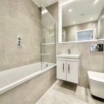 Modern bathroom with bathtub, vanity, and toilet.