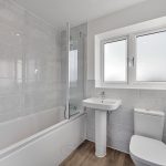 Modern bathroom with bathtub, sink, and window.